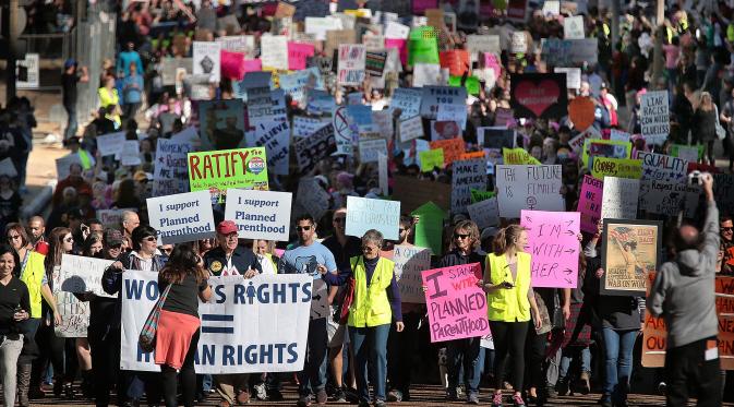 Demonstran berjalan kaki di Memphis, AS, Sabtu (21/1). Aksi ini merupakan aksi protes yang menolak Trump karena kebencian dan rasisme yang selama ini sering dilayangkannya. (AP Photo)