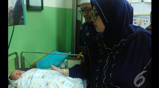 Apoy dan istri mengunjungi seorang bayi yang ditinggal orangtuanya di sebuah SPBU di kawasan Pondok Jagung Timur, Tangerang Selatan. Si bayi kini dirawat di Puskemas Pondok Aren. (Pramita Tristiawati/Liputan6.com)