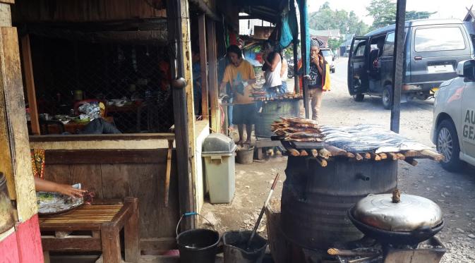 Sejak pagi buta, para pedagang jepa mandar dan ikan tuing-tuing yang berada di kedai-kedai kecil di sisi kanan dan kiri jalan sudah sibuk menyalakan bara api. (Liputan6.com/Fauzan)