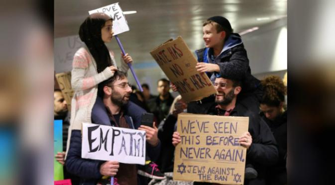Foto yang memperlihatkan bocah muslim dan yahudi di sebuah unjuk rasa menentang kebijakan Trump membuat netizen terenyuh. (Chicago Tribune/Nuccio DiNuzzo)