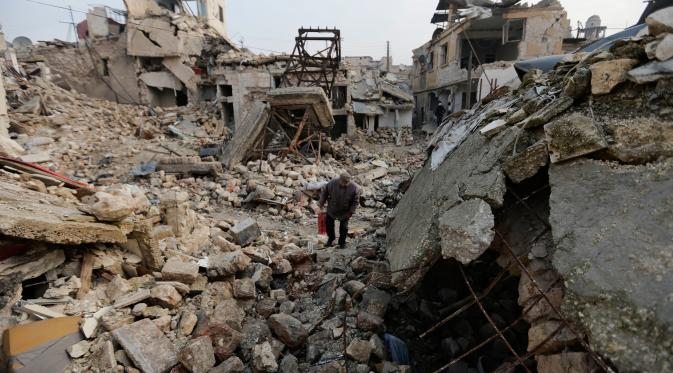 Seorang warga berjalan diantara puing-puing bangunan yang hancur di kawasan Allepo Timur, Suriah (20/1). Aleppo kini dikuasai penuh oleh pemerintah, setelah jatuh ke tangan pemberontak, pada Juli 2012. (AP/Hassan Ammar)