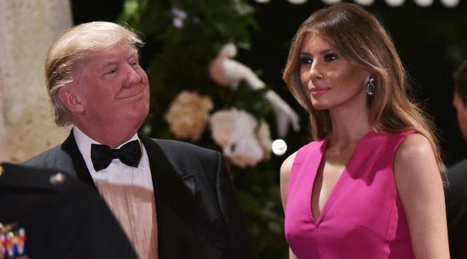 Ekpresi Melania Trump saat mendampingi Donald Trump menghadiri gala tahunan Palang Merah Amerika ke-60 di Mar-a-Lago, Florida, AS (4/2). (AFP/Mandel Ngan)