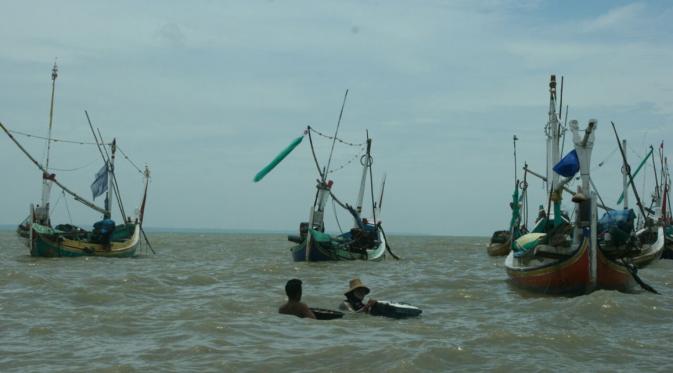 Sejumlah nelayan Sumenep, Madura, berenang dan memindahkan peralatan perahu miliknya. (Liputan6.com/Mohamad Fahrul)