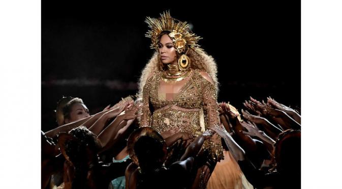 Walaupun hamil, Beyonce tetap tampil seksi dalam balutan busana bernuansa emas pada Grammy Awards 2017. (Foto: Eonline.com)