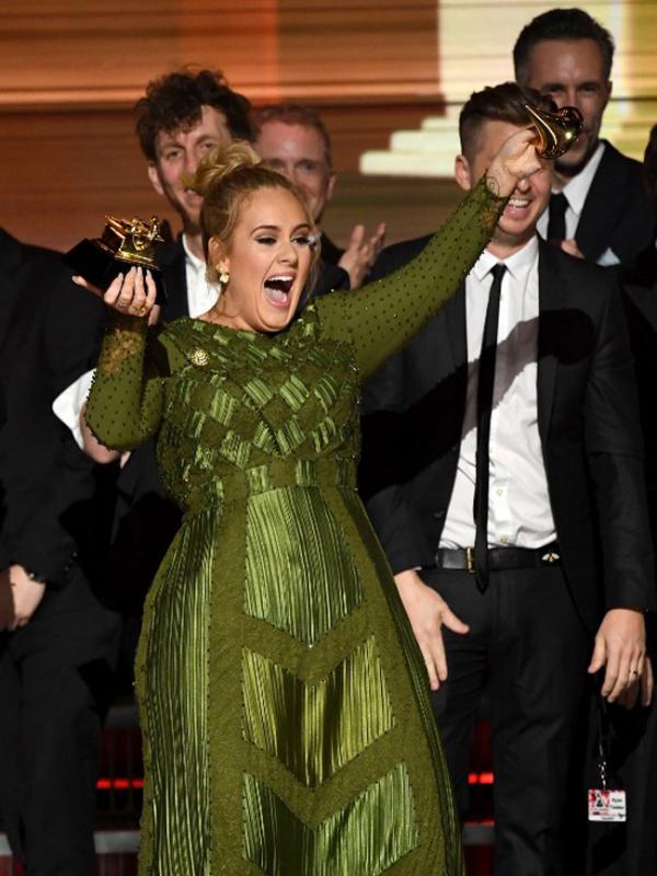 Pemborong lima piala dan pembuka acara di Grammy Awards 2017, Adele malah mematahkan piala di atas panggung lantaran merasa tidak pantas menerima penghargaan itu serta membaginya kepada Beyonce. (AFP/Bintang.com)