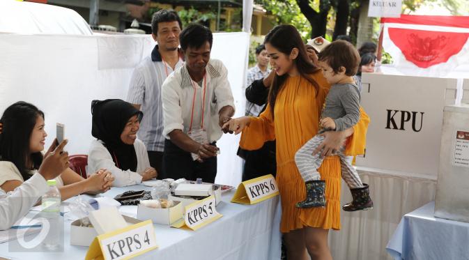 Aktris Jessica Iskandar  memasukan tangan ke tinta untuk mengikuti Pilkada serentak di TPS 22 jalan Bukti Tunggul, Setia Budi, Jakarta, Rabu (15/2). (Liputan6.com/Herman Zakharia)