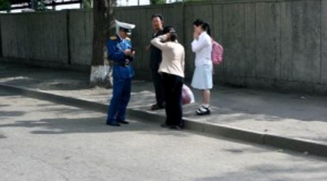 Fashion Police di Korea Utara yang bertugas mengawasi masyarakat agar tidak melanggar larangan berpakaian. Sumber: New Focus International.