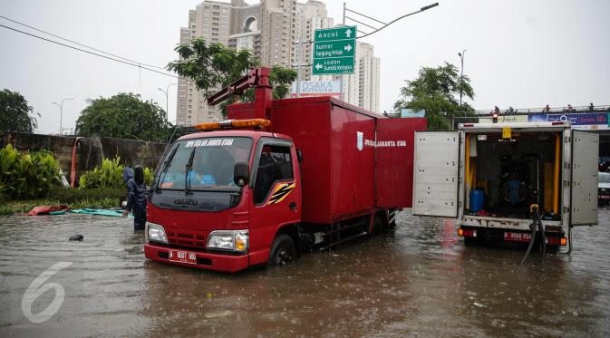 Mobil pompa penyedot air Dinas Tata Air dikerahkan untuk menyedot air banjir yang merendam Jalan Gunung Sahari, Jakarta, Selasa (21/2). Hujan yang mengguyur sejak Selasa dinihari membuat sebagian wilayah di Jakarta banjir. (Liputan6.com/Faizal Fanani)