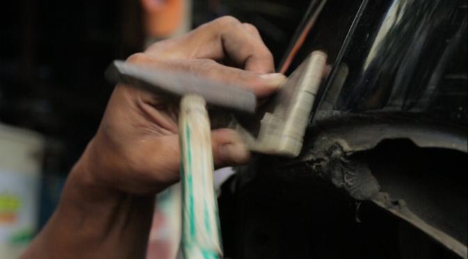 Montir bengkel Ketok Magic sedang memperbaiki penyok di bodi mobil (Liputan6.com/Mochamad Khadafi) 
