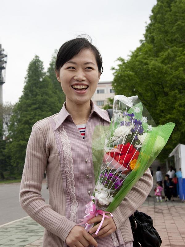 Seorang perempuan membawa bunga di Pyongyang. (Via: boredpanda.com)
