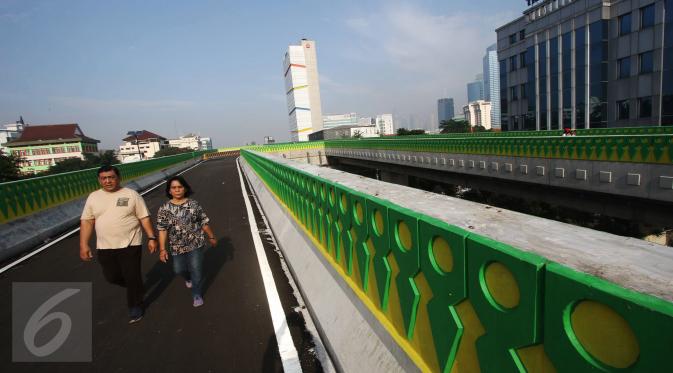 Warga berjalan santai di sepanjang jalan layang Transjakarta rute Cileduk-Tendean di Jakarta, Minggu (26/2). Belum beroperasinya jalan sepanjang 9,3 km tersebut dimanfaatkan warga untuk mengisi kegiatan saat Minggu pagi. (Liputan6.com/Immanuel Antonius)