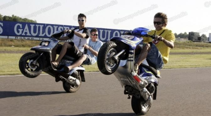 Valentino Rossi melakukan atraksi wheelie (mengangkat roda depan sambil melanju) menggunakan Skuter di Sirkuit Assen, Belanda.(Iconsportsmedia)
