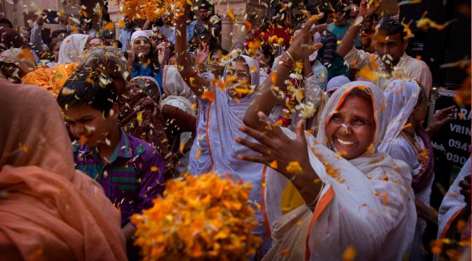 Para janda India melemparkan kelopak bunga saat menghadiri festival holi di kota Vrindavan, India, (9/3). Holi merupakan festival awal musim semi yang ditandai dengan aksi melempar bubuk berwarna-warni. (AP Photo /Manish Swarup)