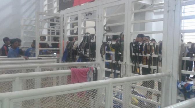 Petugas keamanan mengamankan ikat pinggang suporter demi kenyamanan menyaksikan laga di dalam stadion. (Liputan6.com/Luthfie Febrianto)
