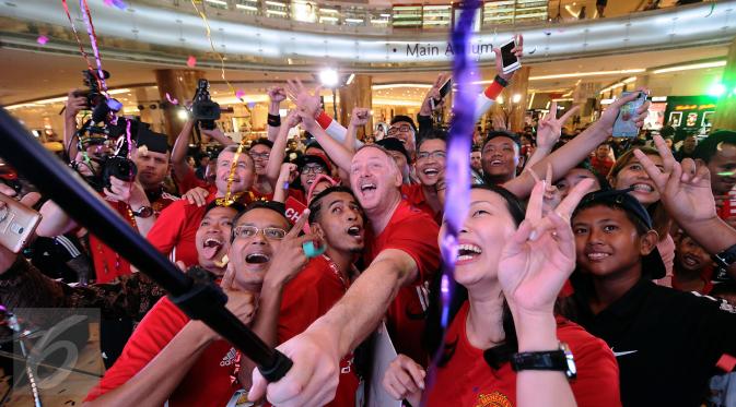 Legenda Manchester United David May (tengah) berswafoto bersama penggemarnya usai pemberian hadiah pemenang Chevrolet Fan Club di Jakarta, Jumat (17/3). Empat pemenang berhak hadiah perjalanan ke Stadion Old Trafford. (Liputan6.com/Helmi Fithriansyah)