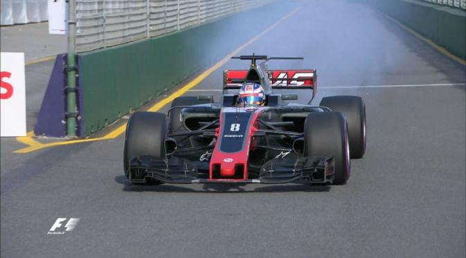 Mobil pebalap Haas, Romain Grosjean, mengeluarkan asap pada balapan F1 GP Australia di Albert Park, Melbourne, Minggu (26/3/2017). (Bola.com/Twitter/F1)