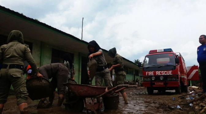 Warga dibantu aparat membersihkan sisa banjir bandang yang menerjang Kota Padang Sidempuan, Sumut. (Liputan6.com/Reza Efendi)