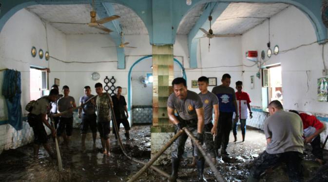 Warga dibantu aparat membersihkan sisa banjir bandang yang menerjang Kota Padang Sidempuan, Sumut. (Liputan6.com/Reza Efendi)