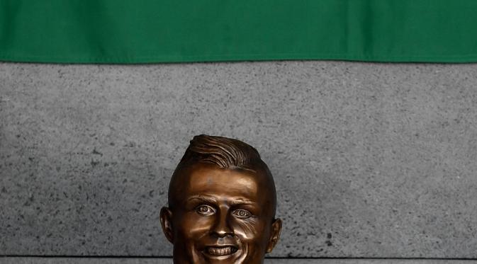 Patung perunggu wajah Cristiano Ronaldo sebagai ikon pada seremoni peresmian Bandara Cristiano Ronaldo, di Funchal, Portugal, Rabu (29/3). Di media sosial, netizen mem-bully patung kepala Ronaldo lantaran tidak mirip dengan aslinya. (FRANCISCO LEONG/AFP)