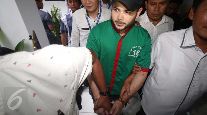 Penyanyi dangdut Ridho Rhoma dibawa petugas usai menjalani pemeriksaan di BNN, Jakarta, Kamis (30/3). Ridho Rhoma ditangkap polisi karena kedapatan mengkonsumsi dan memiliki sabu. (Liputan6.com/Gempur M. Surya)