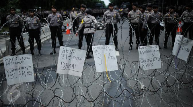 Petugas berjaga saat aksi bela islam 313 di kawasan Jalan Merdeka Barat, Jakarta, Jumat (31/3). Mereka menuntut kepada Presiden Jokowi agar melaksanakan undang-undang dengan mencopot gubernur terdakwa, Ahok. (Liputan6.com/Faizal Fanani)