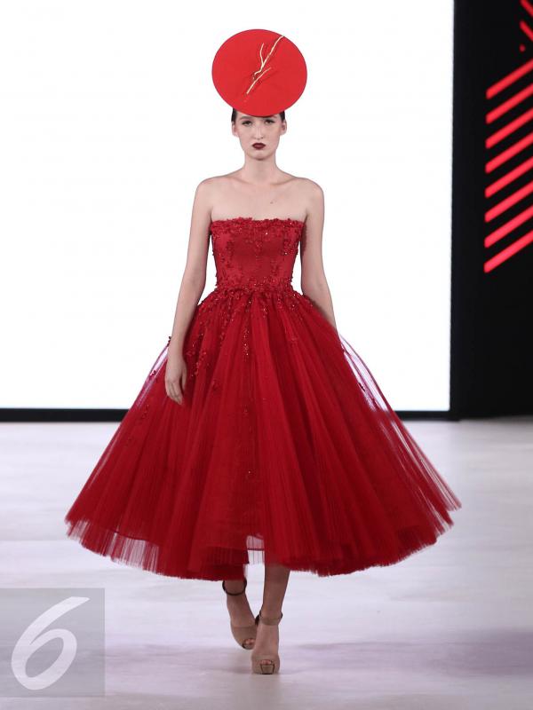 Seorang model mengenakan busana rancangan teranyar Yogie Pratama dalam gelaran Fashion Nation Eleventh Edition (FNXI) di Senayan City, Jakarta, Kamis (6/4). Sebanyak 15 busana wanita hadir dalam nuansa warna merah menyala. (Liputan6.com/Herman Zakharia)