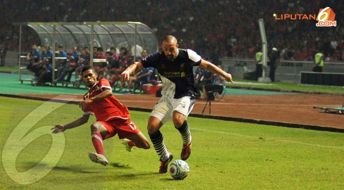 Full back Liverpool Jose Enrique berlari sambil membawa bola untuk melepas kejaran pemain Indonesia XI. (Liputan6.com/Helmi Fithriansyah)