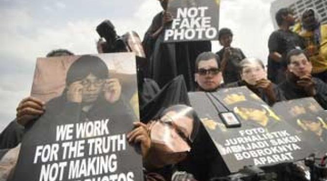 Aksi solidaritas pewarta foto dari berbagai media memakai topeng tersangka mafia pajak Gayus Tambunan di Bundaran HI, Jakarta, Senin (15/11). (Antara)