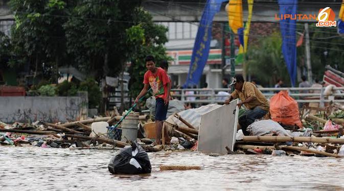 Sejumlah pemulung mengais sampah-sampah yang hanyut terbawa arus Kali Ciliwung yang melintas di jembatan Jalan KH Abdullah Syafei, Jakarta Timur, Rabu 22/01/2014. (Liputan6.com/Helmi Fithriansyah).