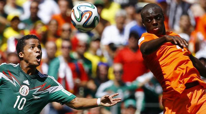 Bek Belanda Bruno Martins Indi (Kanan) berebut bola dengan penyerang Meksiko Giovani Dos Santos (Kiri) (REUTERS/Dominic Ebenbichler)