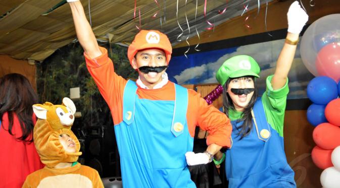 Pasangan Fitri Tropica dan Irfan Hanafi  berkostum sepasang sahabat tukang pipa, Mario dan Luigi di acara ulang tahun kejutan untuk manajer Fitrop di Inbek Manajemen, Jakarta, Selasa(22/7/14). (Liputan6.com/Panji Diksana)