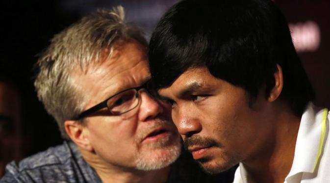 Petinju Filipina, Manny Pacquiao (kanan), mendengarkan arahan pelatihnya, Freddie Roach, dalam jumpa pers jelang laga melawan Chris Algieri di Shanghai, Tiongkok, (26/8/2014). (REUTERS/Carlos Barria)