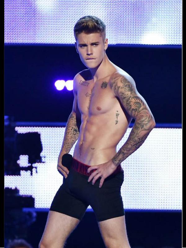 Justin Bieber berpose usai membuka pakaiannya di atas panggung acara 