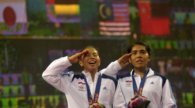 Nitya Krishinda (kanan) dan Gresya Polii menyanyi Indonesia Raya ketika pengibaran bendera merah putih di Gyeyang Gymnasium, Incheon, Korsel, (27/9). (ANTARA FOTO/SAPTONO)