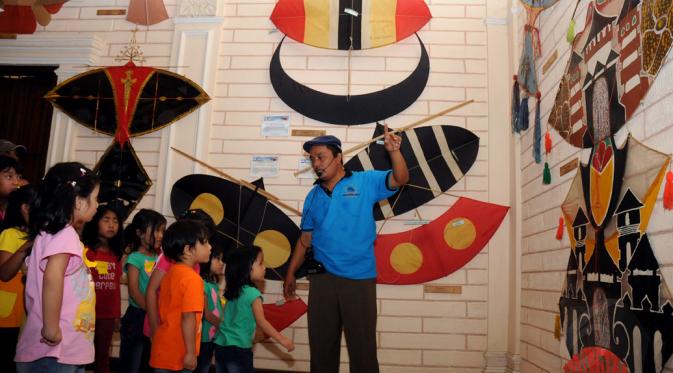 Bersama salah satu pemandu, sejumlah anak berkeliling dan melihat-lihat koleksi layang-layang yang ada di Museum Layang-Layang, Jakarta, (27/9/2014). (Liputan6.com/Helmi Fithriansyah)