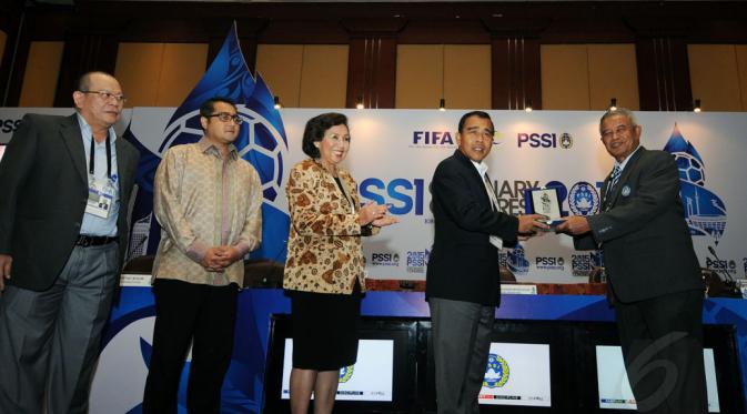 Ketua Umum PSSI, Djohar Arifin Husin (kanan) memberikan plakat kepada Ketua KONI Pusat, Tono Suratman (kedua dari kanan) usai membuka Kongres Tahunan PSSI di Hotel Borobudur, Jakarta (4/1/2015). (Liputan6.com/Helmi Fithriansyah)