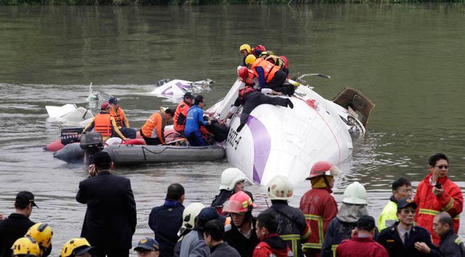 Tim penyelamat mengevakuasi penumpang yang terjebak di badan pesawat yang tenggelam di Sungai Taipei, Taiwan, Rabu (4/2/2015). Pesawat yang mengangkut 58 penumpang dan awak pesawat itu terhempas ke sungai saat hendak lepas landas. (REUTERS/Pichi Chuang)
