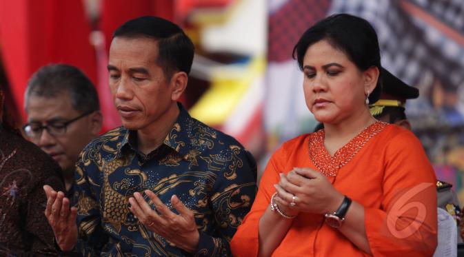 Presiden Joko Widodo didampingi Iriana Widodo saat menghadiri perayaan Cap Go Meh di Kota Bogor, Jawa Barat, Kamis (5/3/2015). Keduanya tampak mengangkat kedua tangan saat pembacaan doa (Liputan6.com/Faizal Fanani)