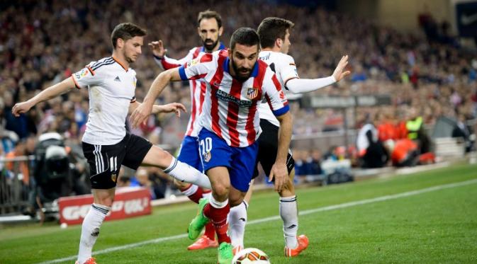 Gelandang Atletico Madrid Arda Turan mencoba melewati hadangan pemain Valencia Pablo Piatti (DANI POZO / AFP)