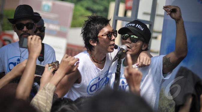 Aksi grup band Slank saat menghibur warga Ibukota di Bundaran HI, Jakarta, Minggu (22/3/2015). Grup musik ini menggelar konser mini untuk memperingati Hari Air Sedunia yang jatuh pada 22 Maret. (Liputan6.com/Faizal Fanani) 