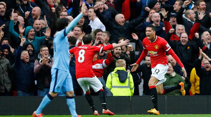 Bek Manchester United, Chris Smalling (kanan)merayakan selebrasi usai mencetak gol ke gawang City saat Laga Liga Premier Inggris di Old Trafford, Minggu (12/4/2015). Manchester United menang 4-2 atas City. (Reuters/Darren Staples)