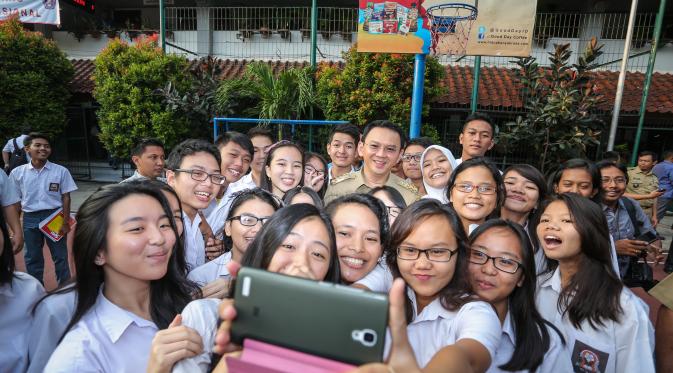 Gubernur DKI Jakarta Basuki Tjahaja Purnama selfie bersama siswa SMA Negeri 2, Jakarta, Selasa (14/4/2015). (Liputan6.com/ Faizal Fanani) 