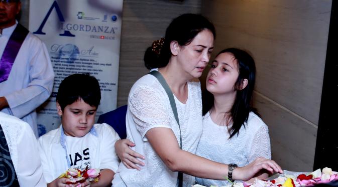Roweina memeluk kedua anaknya di tempat kremasi  Alm. James Sahertian (Wimbarsana/bintang.com)