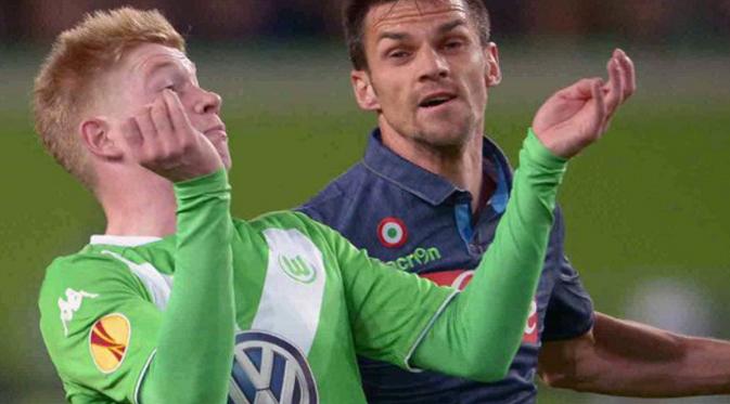 Gelandang Wolfsburg, Kevin De Bruyne mengontrol bola dari kejaran pemain Napoli Christian Maggio di leg pertama perempat final Liga Europa di Stadion Volkswagen Arena, Kamis (16/4/2015). Napoli menang 4-1 atas Wolfsburg.(AFP PHOTO/Peter Steffen)