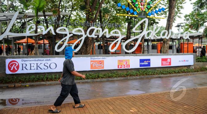 Kios 'Lenggang Jakarta' kini mulai ramai didatangi pengunjung di kawasan Monas, Jakarta, Jumat (17/4/2015). Seorang warga tampak melintas  di depan Kios 'Lenggang Jakarta'. (Liputan6.com/Faizal Fanani)