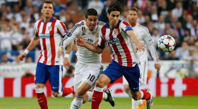 Penyerang Real Madrid, James Rodriguez berusaha merebut bola dari pemain Atletico Madrid Tiago Mendes di leg kedua 8 besar Liga Champions di Santiago Bernabeu Stadium, Kamis (23/4/2015). Real Madrid menang 1-0 atas Atletico Madrid. (Reuters/Sergio Perez)