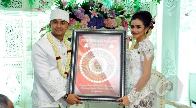 Hengky Kurniawan dan Sonya Fatmala memperlihatkan mahar pernikahan mereka seusai prosesi akad nikah di sebuah hotel kawasan TMII, Jakarta, Kamis (23/4/2015). (Liputan6.com/Panji Diksana)