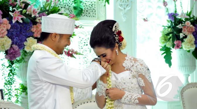 Sonya Fatmala saat mencium tangan Hengky Kurniawan usai melangsungkan akad nikah di sebuah hotel kawasan TMII, Jakarta, Kamis (23/4/2015). (Liputan6.com/Panji Diksana)