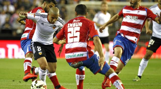 Gelandangan Valencia Sofiane Feghouli mencoba melewati hadangan para pemain Granada dalam lanjutan La Liga Spanyol (JOSE JORDAN/AFP)