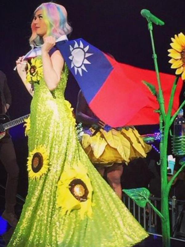 Katy Perry saat menyelempangkan bendera Taiwan di atas panggung. (foto: entertainmentweekly)